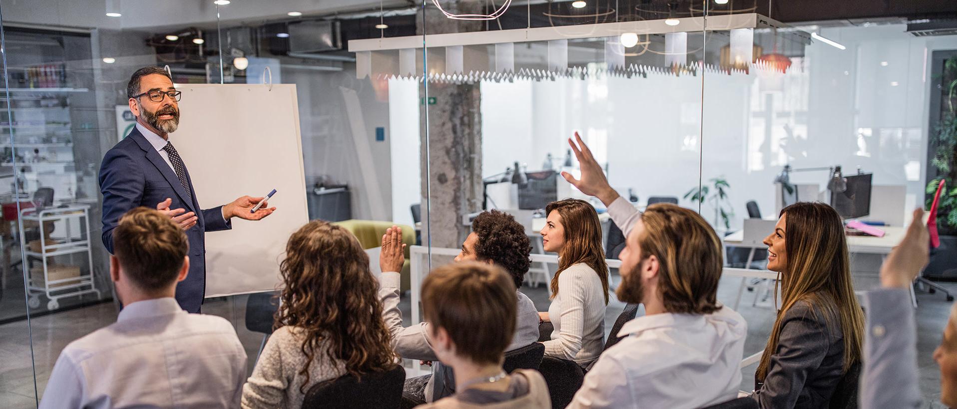 Business man giving training to team in a conference room with a whiteboard