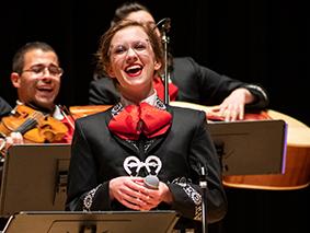 Mariachi singer performing in front of musicians