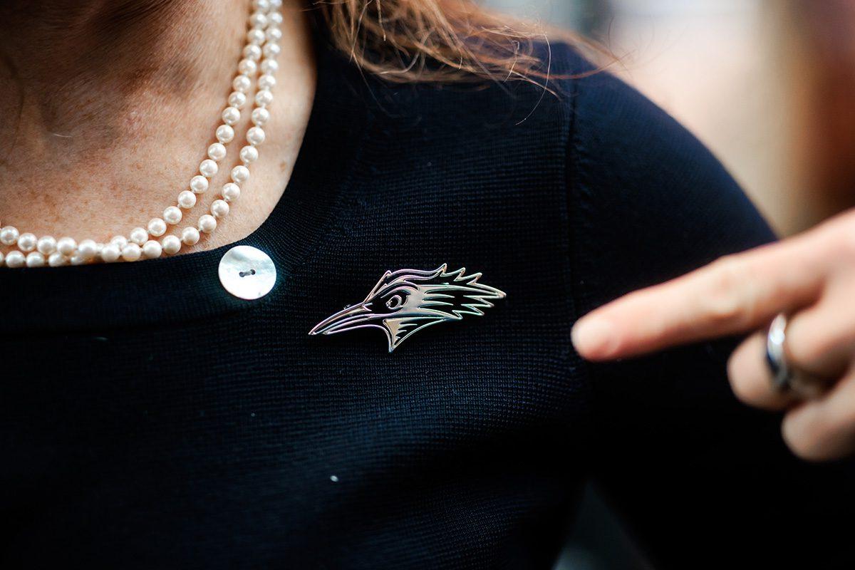 MSU Denver President, Janine Davidson, Ph.D., points to the Roadrunner brooch she's proudly wearing.